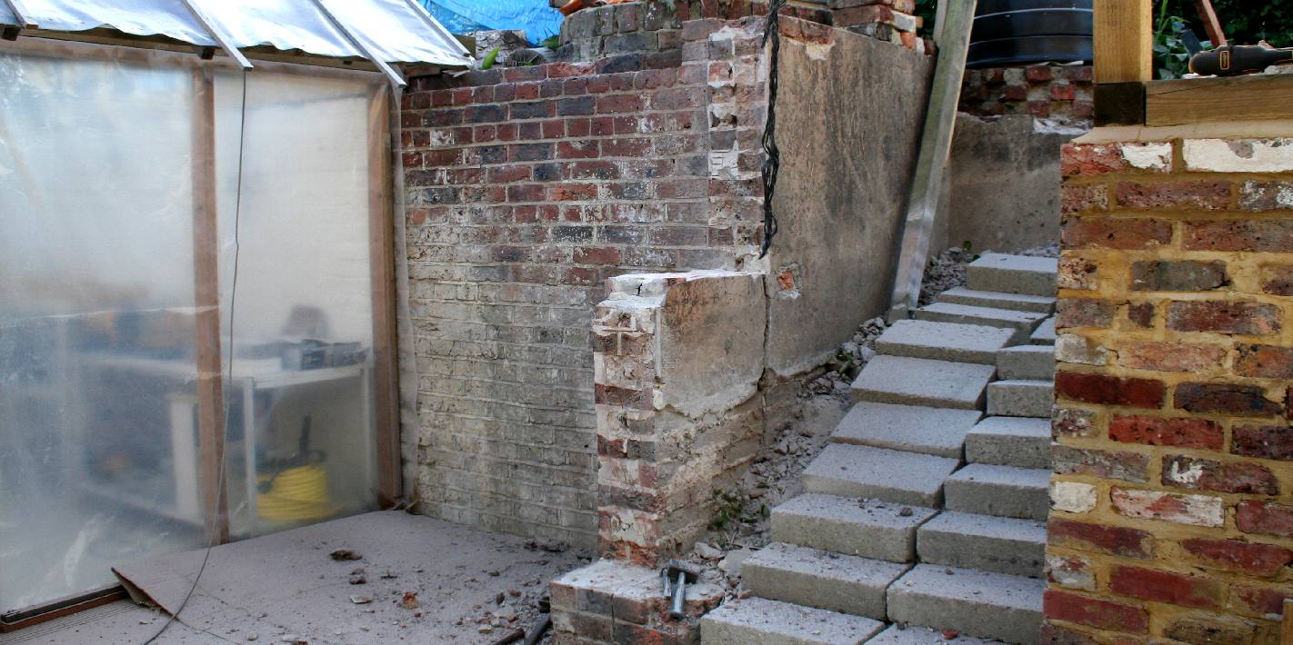 Original courtyard brick retaining wall in need of attention